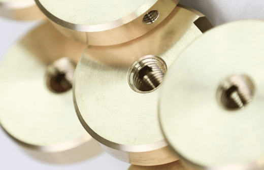 Close-up view of brass circular flanges with threaded holes