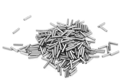 Pile of small stainless steel dowel pins on a white background