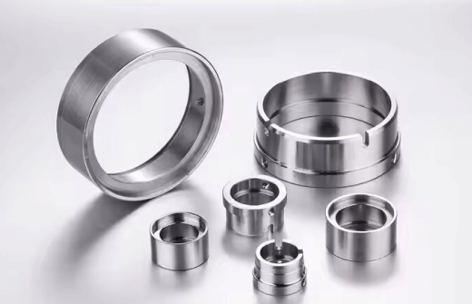 CNC-machined metal rings and cylindrical components.