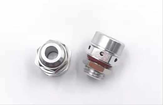 Two metallic cable glands with hexagonal nuts and threaded ends on a white background